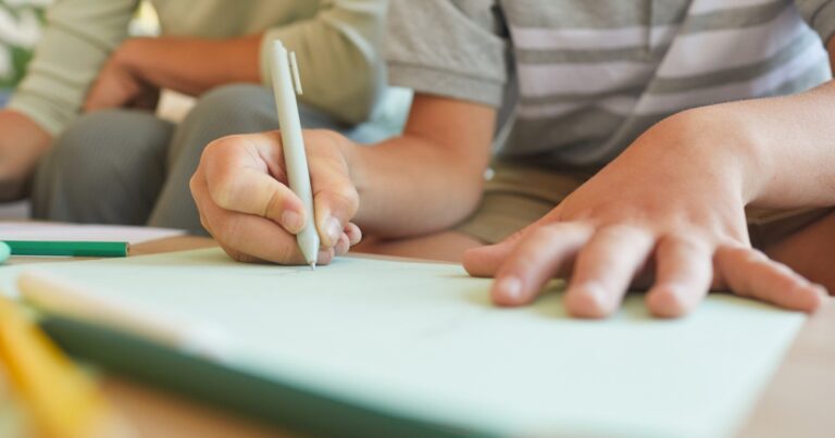 photo of middle school age boy doing homework writing