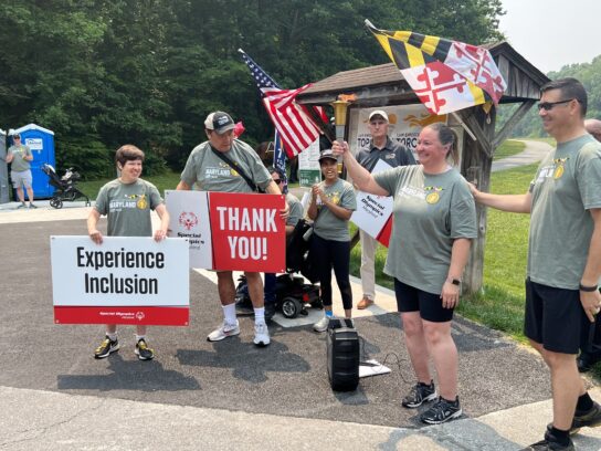 Special Olympics athletes holding the lit torch in preparation for the run.