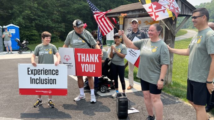 Special Olympics athletes holding the lit torch in preparation for the run.